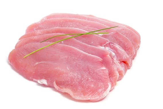 Some slices of raw turkey meat on a white background